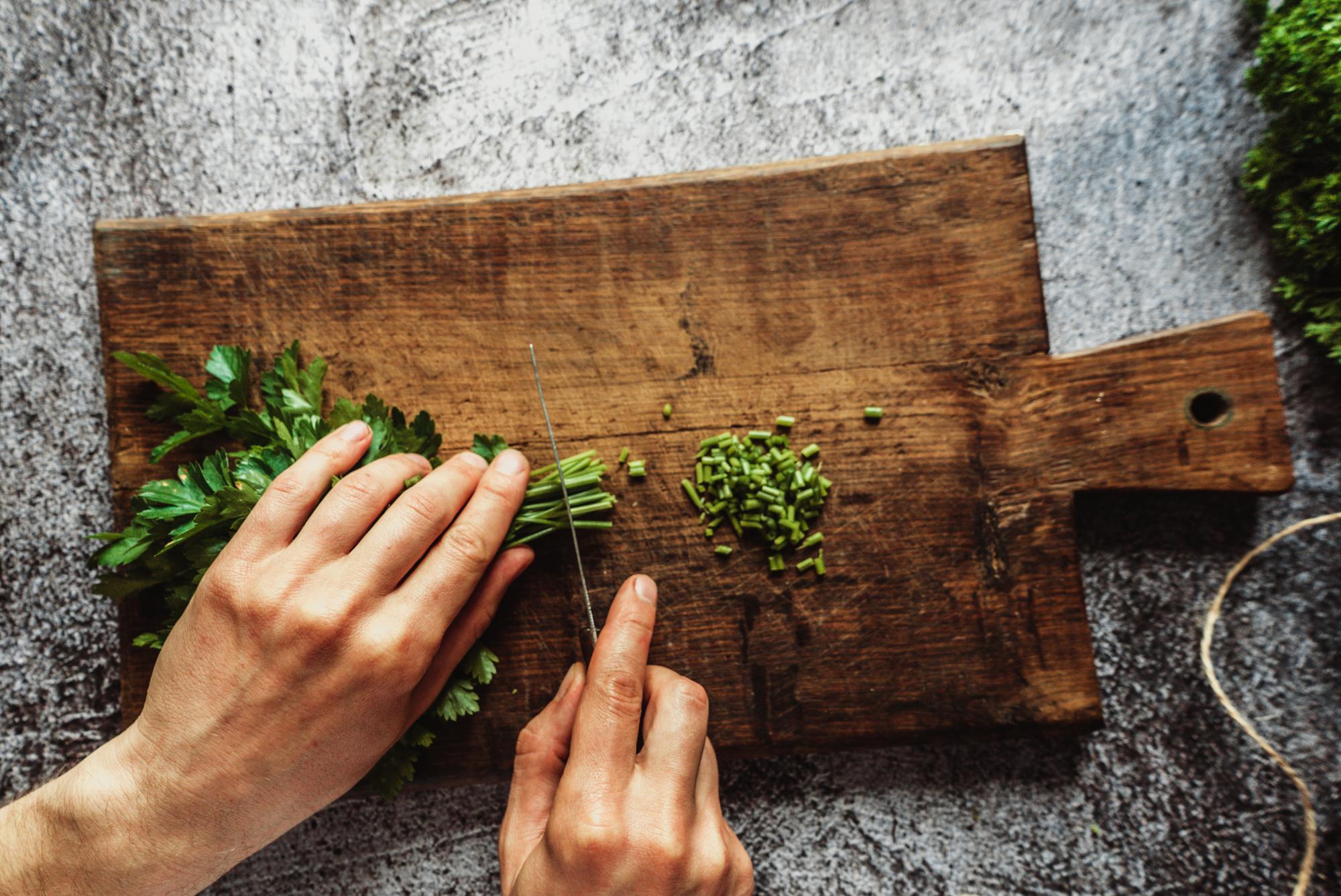 Close-up of hands preparing fresh herbs